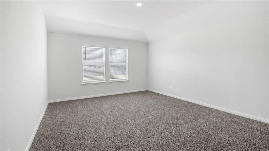 320 Ridan Drive, Waxahachie, TX 75165 Spacious room featuring gray carpet, white walls, and a vaulted ceiling with a recessed light fixture