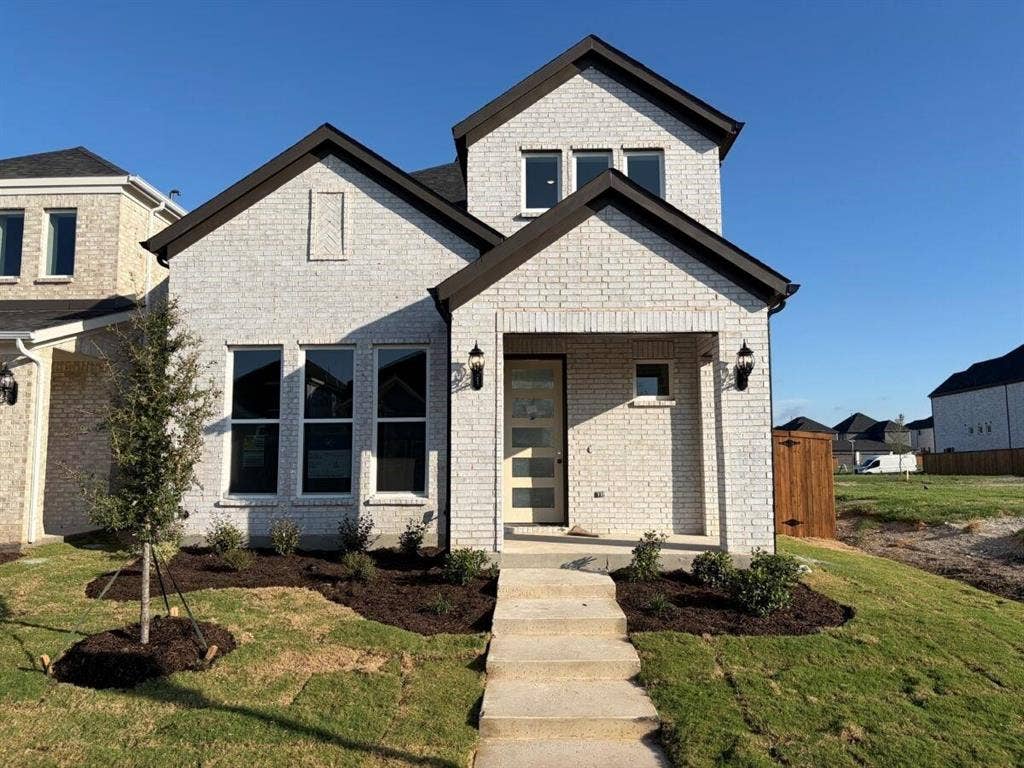 11632 Empress Drive, Frisco, TX 75035 Light brick exterior featuring dark trim, multi-gabled roofline, covered entryway, and multi-pane front door