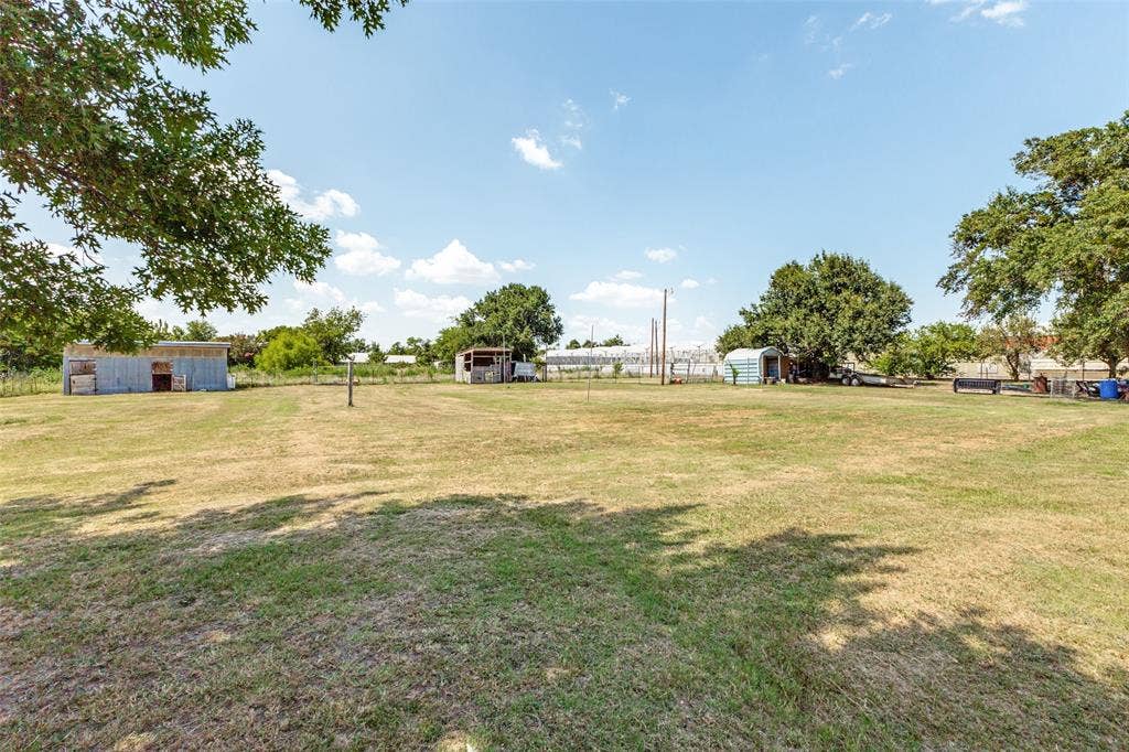 7400 County Road 131A, Terrell, TX 75161 Expansive open acreage featuring mature trees, peripheral fencing, and multiple detached outbuildings