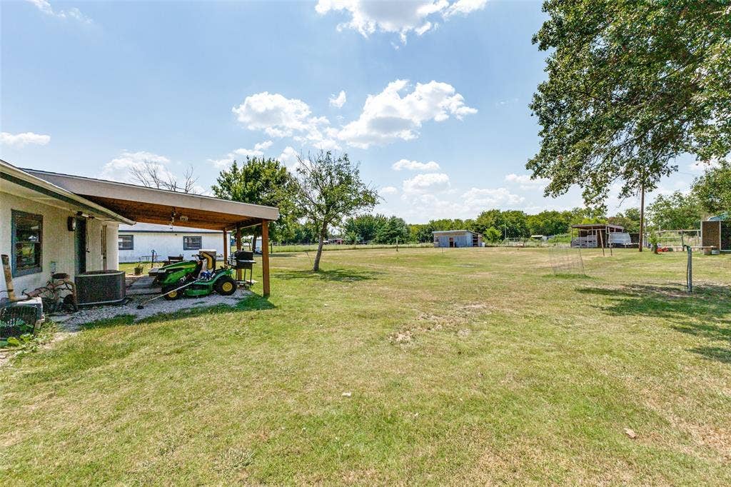 7400 County Road 131A, Terrell, TX 75161 Expansive grounds featuring a covered patio, mature trees, and open green space