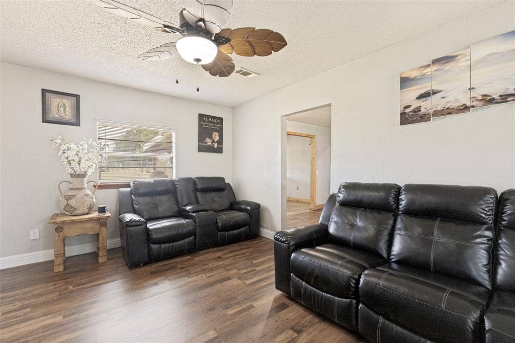 7400 County Road 131A, Terrell, TX 75161 Wood-finish flooring, palm-leaf design ceiling fan with integrated lighting, and neutral-toned wall finish