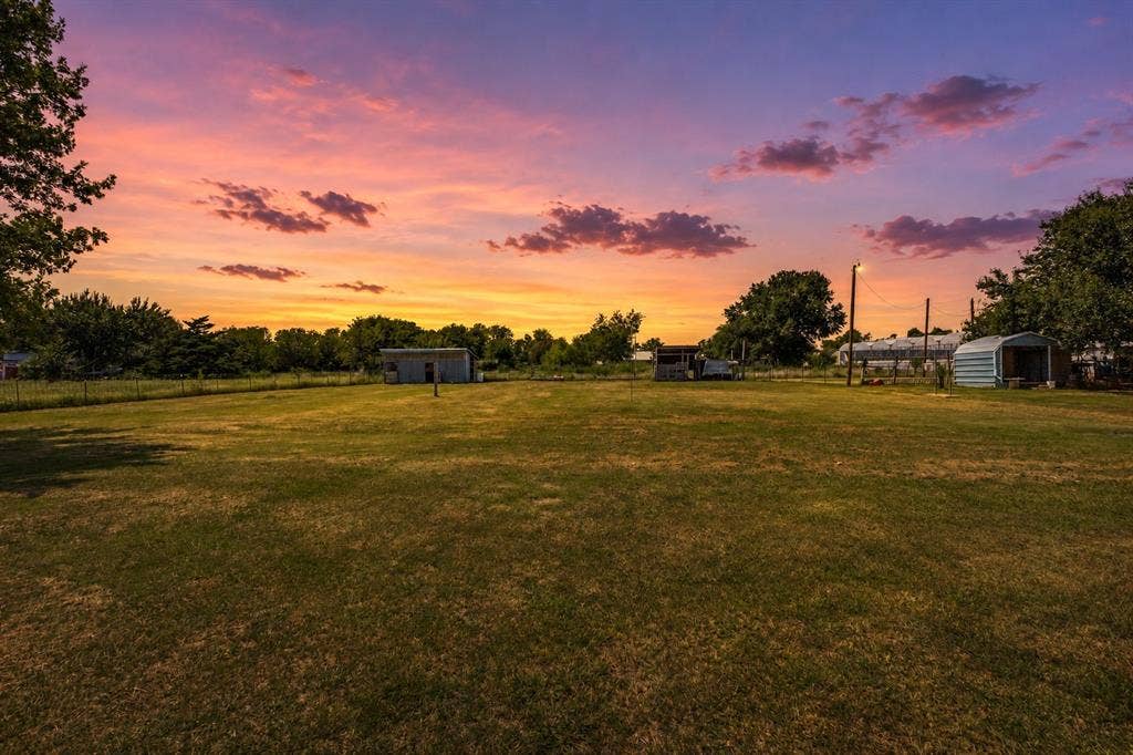 7400 County Road 131A, Terrell, TX 75161 Expansive parcel featuring level terrain, mature trees, open green space, and multiple detached metal structures