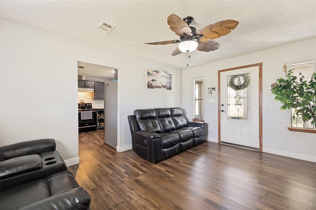 7400 County Road 131A, Terrell, TX 75161 Living area featuring wood-finish flooring, a ceiling fan with leaf-shaped blades, and an exterior door with decorative glass inlay