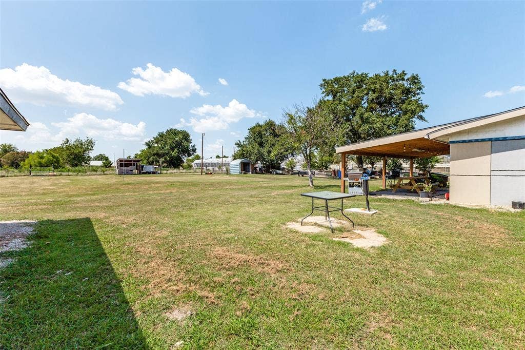 7400 County Road 131A, Terrell, TX 75161 Expansive grass lot featuring a covered patio and mature trees