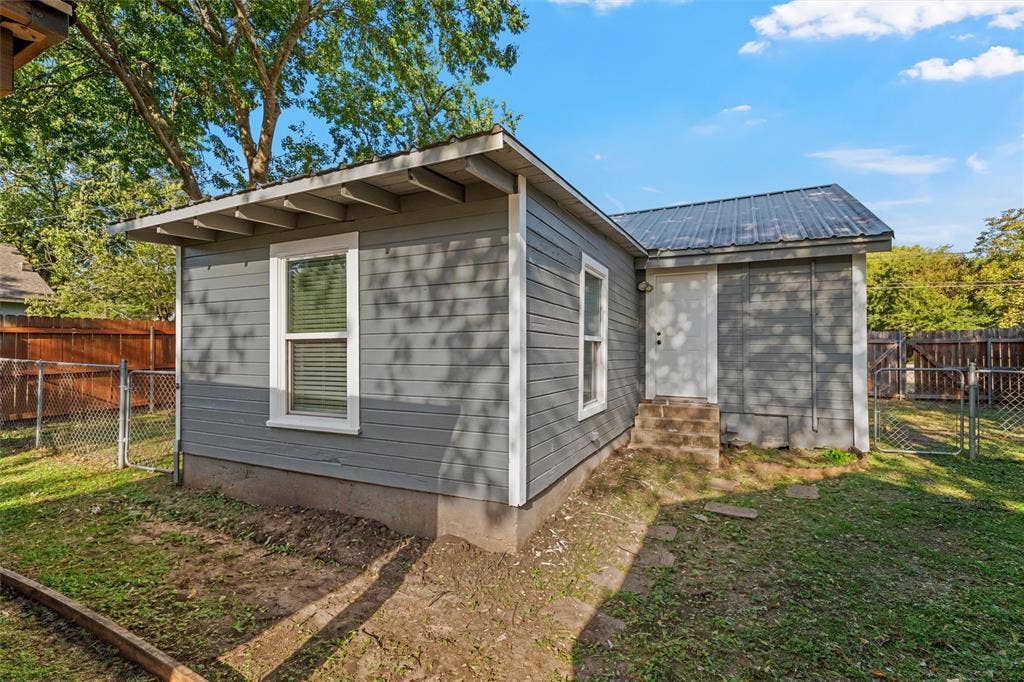 2222 Speight Avenue, Waco, TX 76706 Exterior featuring horizontal lap siding, a metal roof, dual-pane windows, and a fenced backyard
