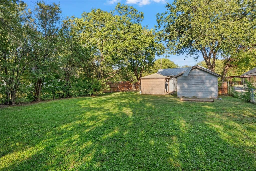 2222 Speight Avenue, Waco, TX 76706 Expansive backyard featuring a large grass lawn, mature trees, and wooden perimeter fencing