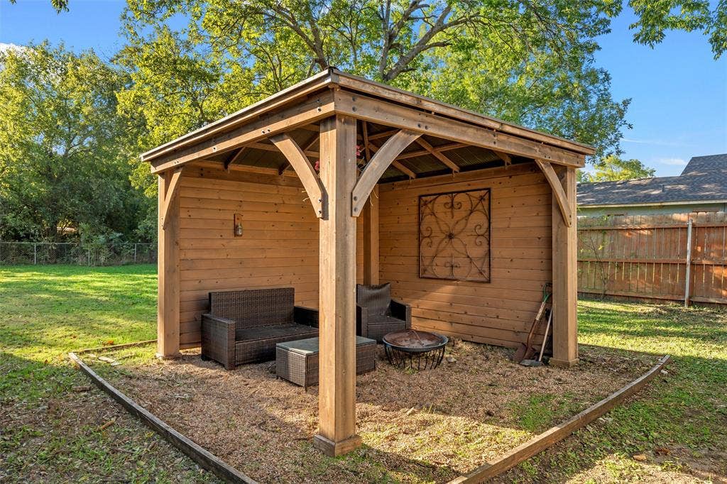 2222 Speight Avenue, Waco, TX 76706 Wood-frame gazebo featuring horizontal plank siding, decorative wood support brackets, and a fenced backyard setting