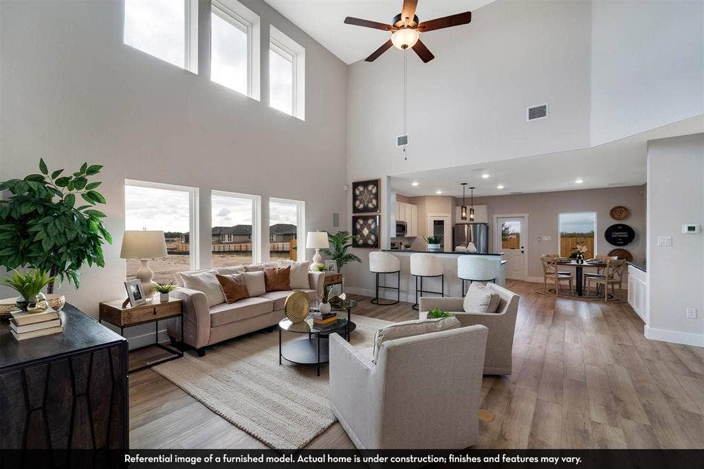 3009 Merrick Drive, Crandall, TX 75114 Expansive living area featuring vaulted ceilings, floor-to-ceiling windows, wood-finish flooring, a ceiling fan, and recessed lighting