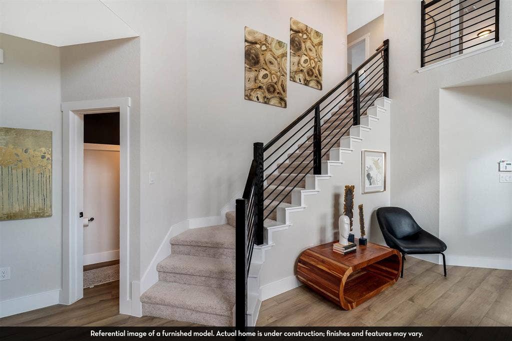 3009 Merrick Drive, Crandall, TX 75114 Foyer featuring a wood-finish floor and a carpeted staircase with a matte black metal railing