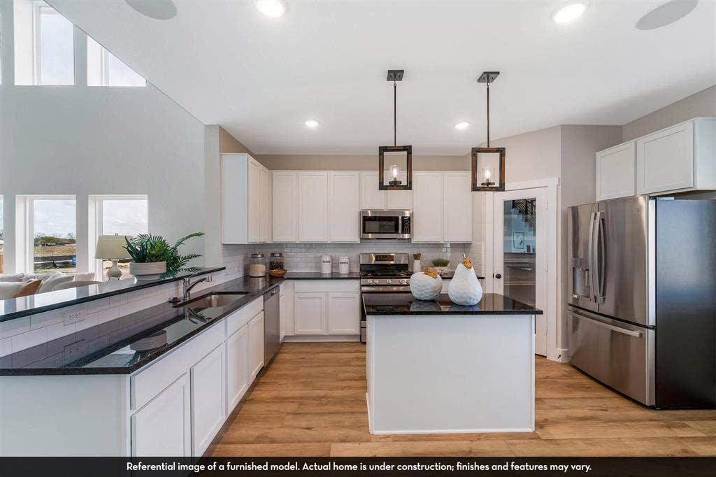 3009 Merrick Drive, Crandall, TX 75114 Kitchen featuring white shaker-style cabinetry, dark stone countertops, stainless steel appliances, central island, and wood-finish flooring