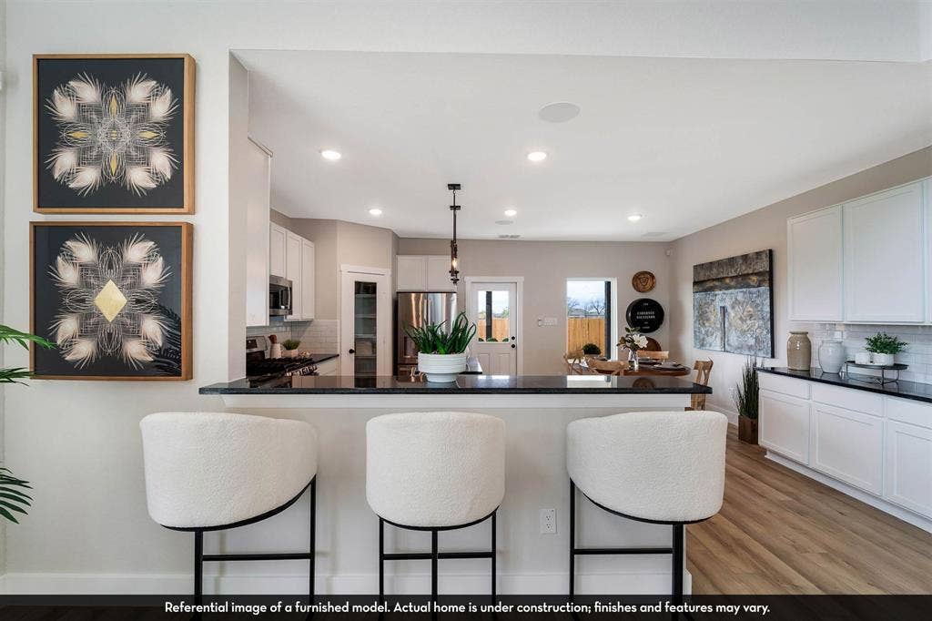 3009 Merrick Drive, Crandall, TX 75114 Kitchen featuring a breakfast bar with dark countertops, white cabinetry, recessed lighting, and wood-finish flooring
