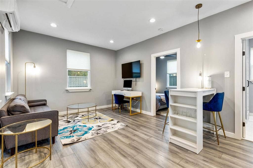 1606 W 12th Street, Dallas, TX 75208 Wood-finish flooring, recessed lighting, wall-mounted air conditioning unit, and pendant lighting
