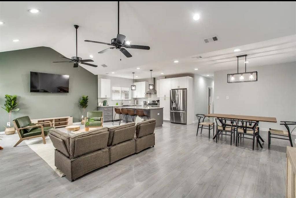 1606 W 12th Street, Dallas, TX 75208 Open-concept interior featuring vaulted ceilings, wood-finish flooring, recessed lighting, and a kitchen equipped with a central island and stainless steel appliances