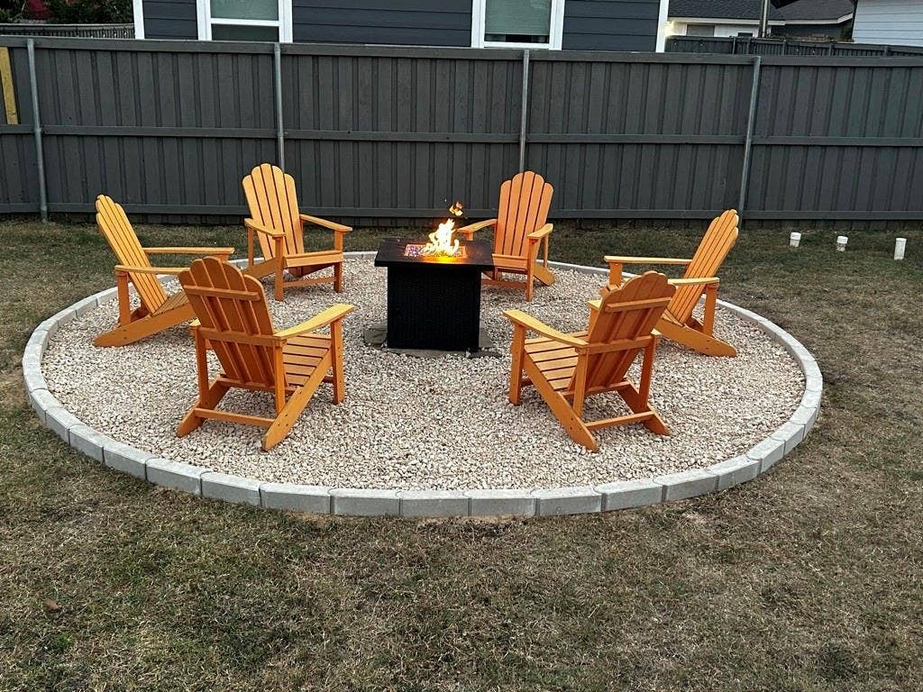 1606 W 12th Street, Dallas, TX 75208 Circular outdoor fire pit area featuring a gravel base, concrete paver edging, and a permanent metal fire pit enclosure