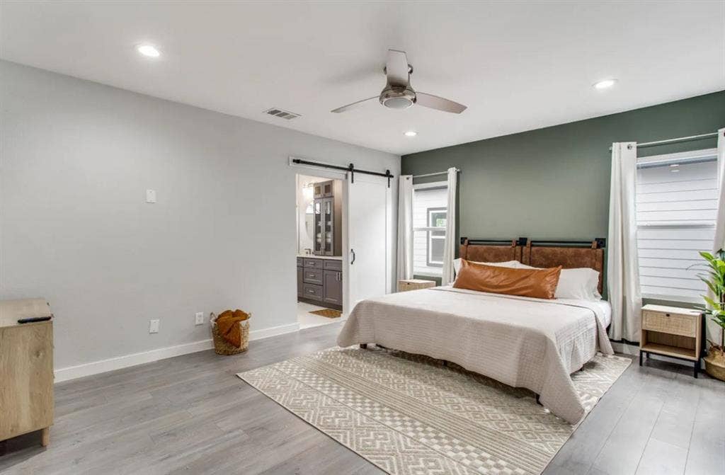 1606 W 12th Street, Dallas, TX 75208 Room featuring wood-finish flooring, recessed lighting, a modern ceiling fan, an accent wall, and a sliding barn door