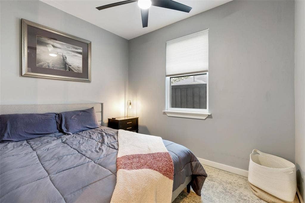 1606 W 12th Street, Dallas, TX 75208 Neutral-toned interior walls, cellular window shade, and matte black ceiling fan