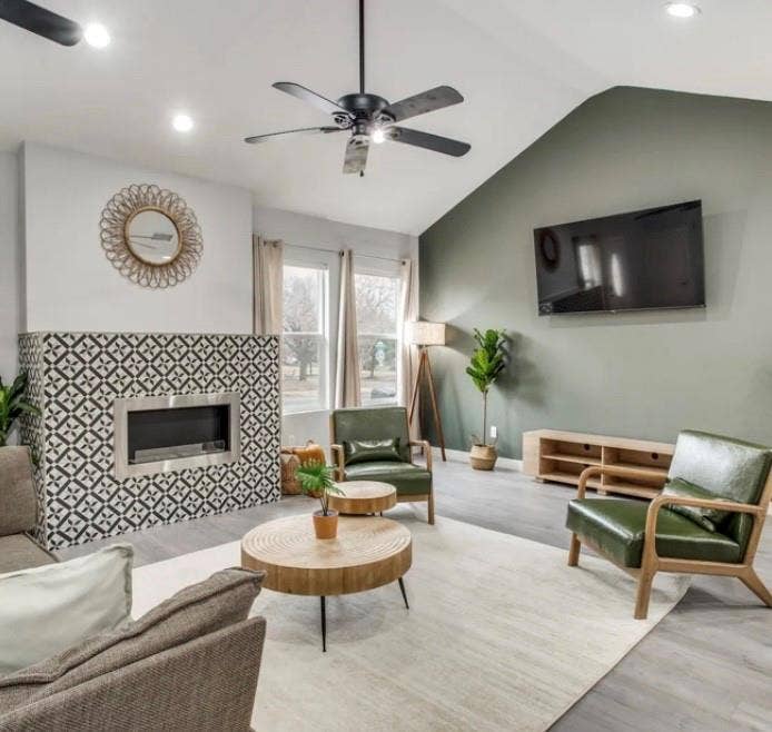 1606 W 12th Street, Dallas, TX 75208 Vaulted ceilings with recessed lighting, a fireplace featuring patterned tile surround, and wood-finish flooring
