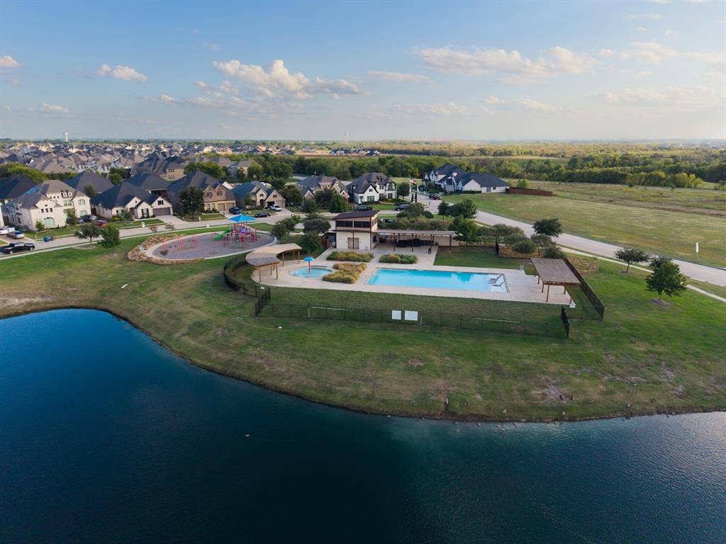 415 Rock Rose Lane, Wylie, TX 75098 Recreational facility featuring an in-ground swimming pool, a separate spa, stone-paver decking, covered pergolas, and a children's play area situated along a waterfront