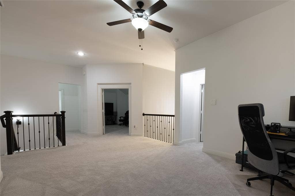 415 Rock Rose Lane, Wylie, TX 75098 Open-concept space featuring neutral carpeting, a ceiling fan with integrated lighting, recessed lighting, and metal balustrade railings
