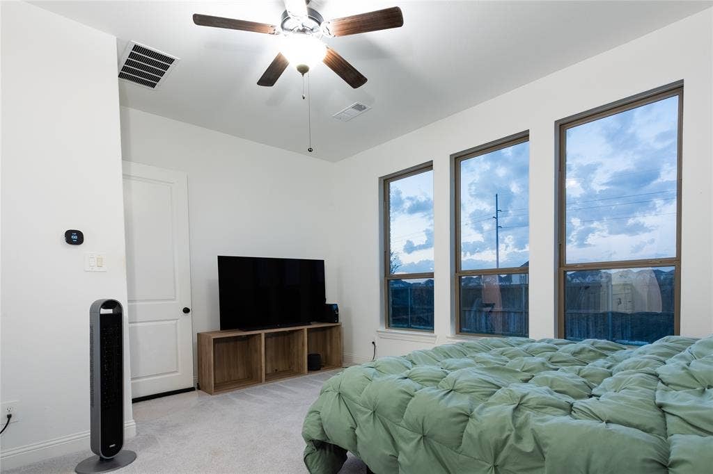 415 Rock Rose Lane, Wylie, TX 75098 Three expansive, vertically-oriented windows, neutral wall coloring, and a five-blade ceiling fan with integrated lighting