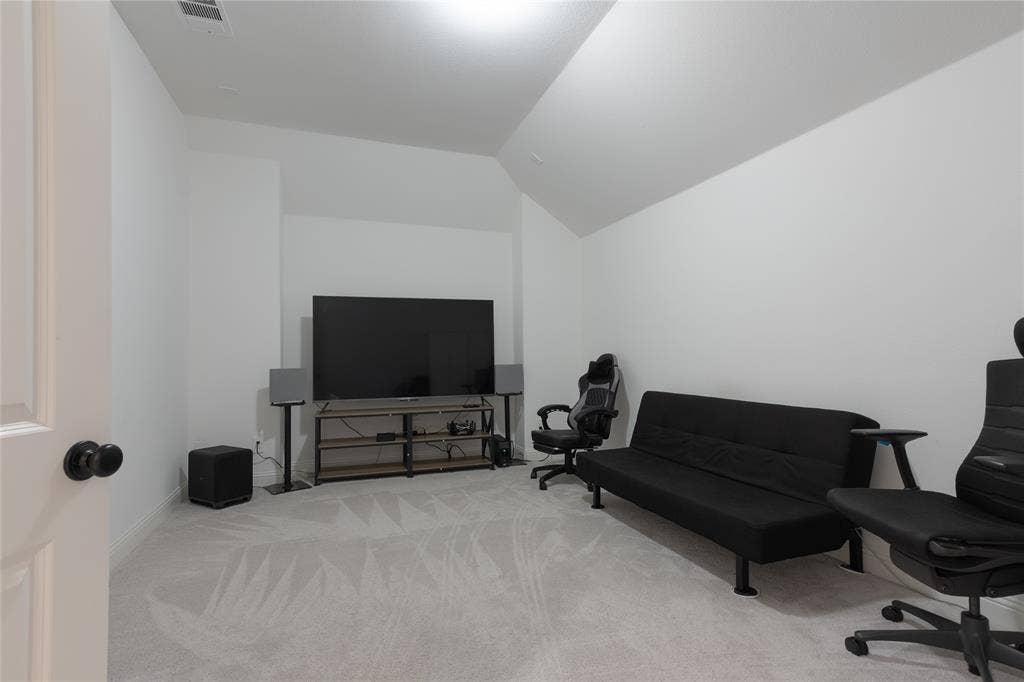 415 Rock Rose Lane, Wylie, TX 75098 Neutral-toned room featuring a vaulted ceiling and wall-to-wall carpeting