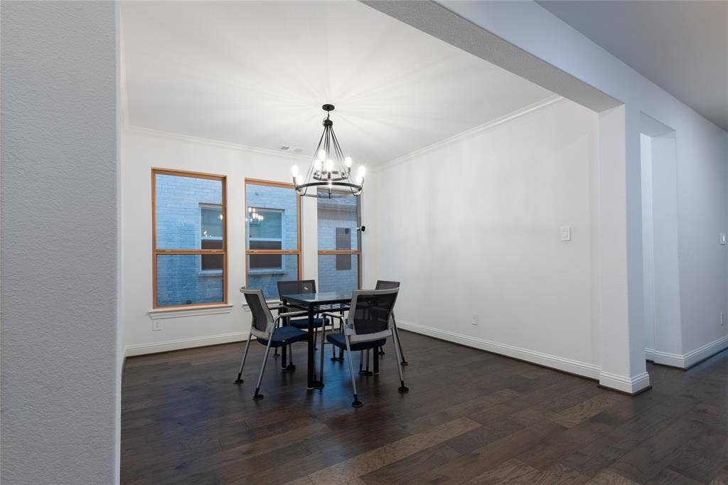 415 Rock Rose Lane, Wylie, TX 75098 Dark wood-finish flooring, three large windows with wood-tone frames, and an industrial-style multi-bulb chandelier