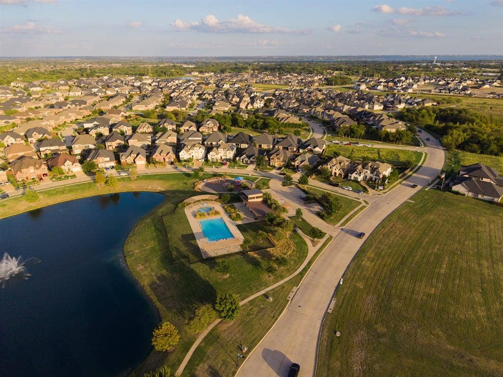 415 Rock Rose Lane, Wylie, TX 75098 Aerial perspective of a community featuring a fenced swimming pool, central water feature with a fountain, paved walking paths, and designated open green space