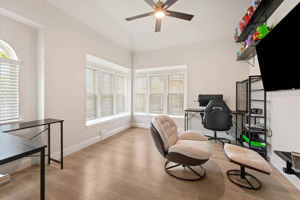 1958 Snowball Lane, Glenn Heights, TX 75154 Office Room featuring wood-finish flooring, recessed window bays, multi-pane windows with integrated blinds, and a ceiling-mounted fan with light fixture