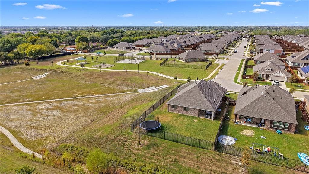 1958 Snowball Lane, Glenn Heights, TX 75154 View of park and community center Aerial perspective featuring multi-pitched shingle roofing, brick masonry exterior, perimeter fencing, and concrete walking paths