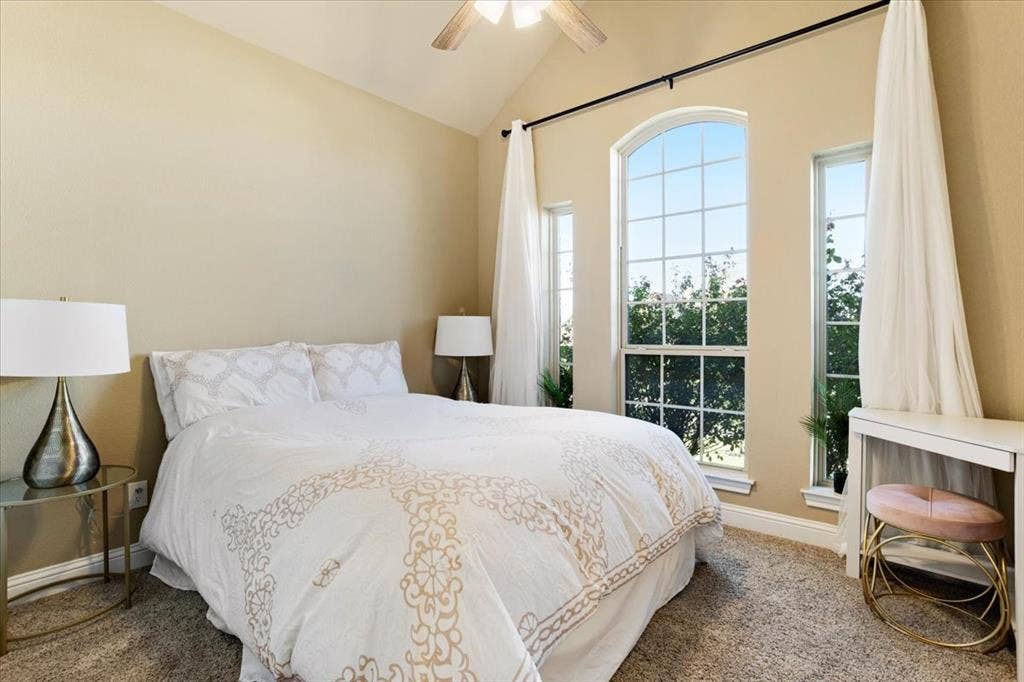 401 Mesa, Lone Oak, TX 75453 Vaulted ceiling featuring a central lighted ceiling fan, expansive triple-pane windows with arched detailing, and plush carpeting
