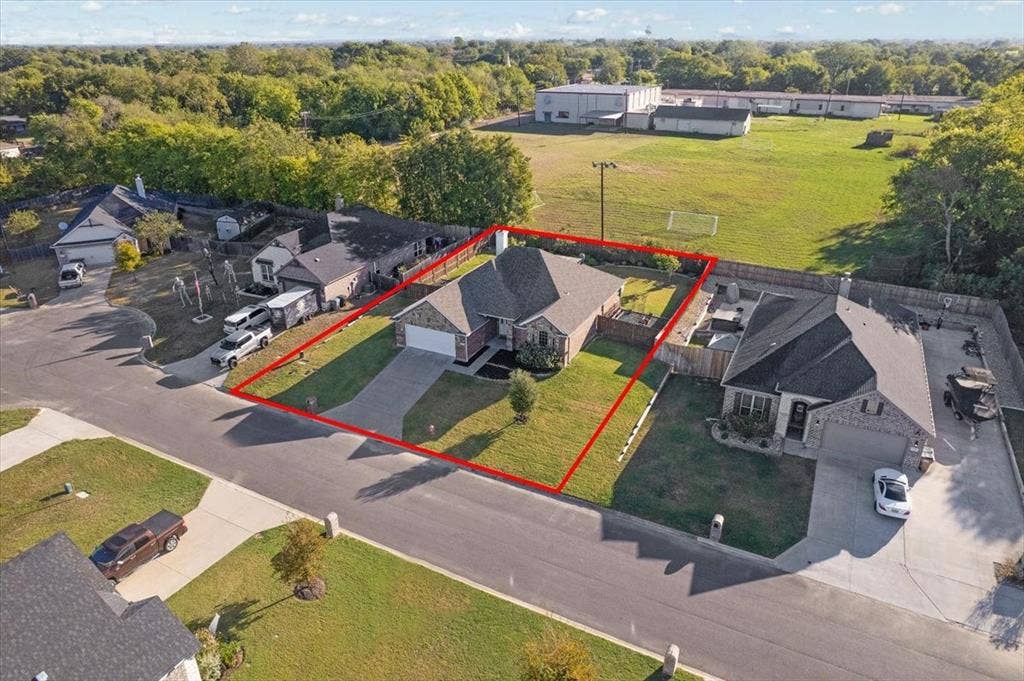 401 Mesa, Lone Oak, TX 75453 Single-story brick and stone veneer exterior featuring a concrete driveway, two-car garage, and enclosed backyard with perimeter wood fencing