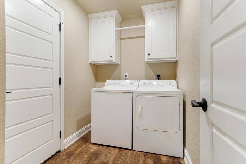 401 Mesa, Lone Oak, TX 75453 Laundry area featuring white shaker-style wall cabinets, a built-in hanging rod, four-panel interior doors, and wood-finish flooring
