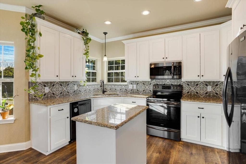 401 Mesa, Lone Oak, TX 75453 Kitchen featuring white shaker cabinetry, stone countertops, patterned tile backsplash, wood-finish flooring, and a central island