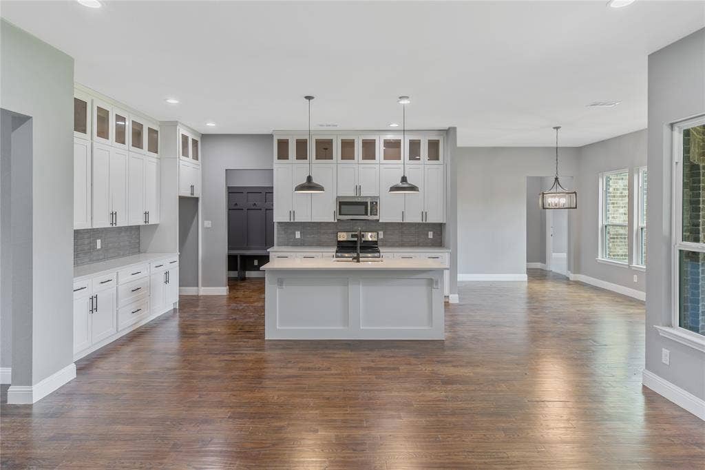 10560 Lago Vista, Quinlan, TX 75474 Kitchen featuring backsplash, glass insert cabinets, hanging light fixtures, recessed lighting, and appliances with stainless steel finishes