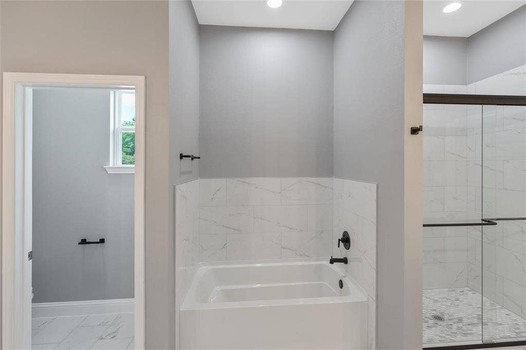 10560 Lago Vista, Quinlan, TX 75474 Full bathroom with a garden tub, marble finish floors, and a stall shower
