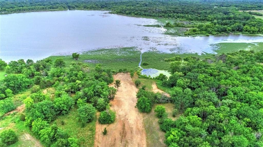 10560 Lago Vista, Quinlan, TX 75474 Aerial view of property and surrounding area featuring a heavily wooded area and a large body of water