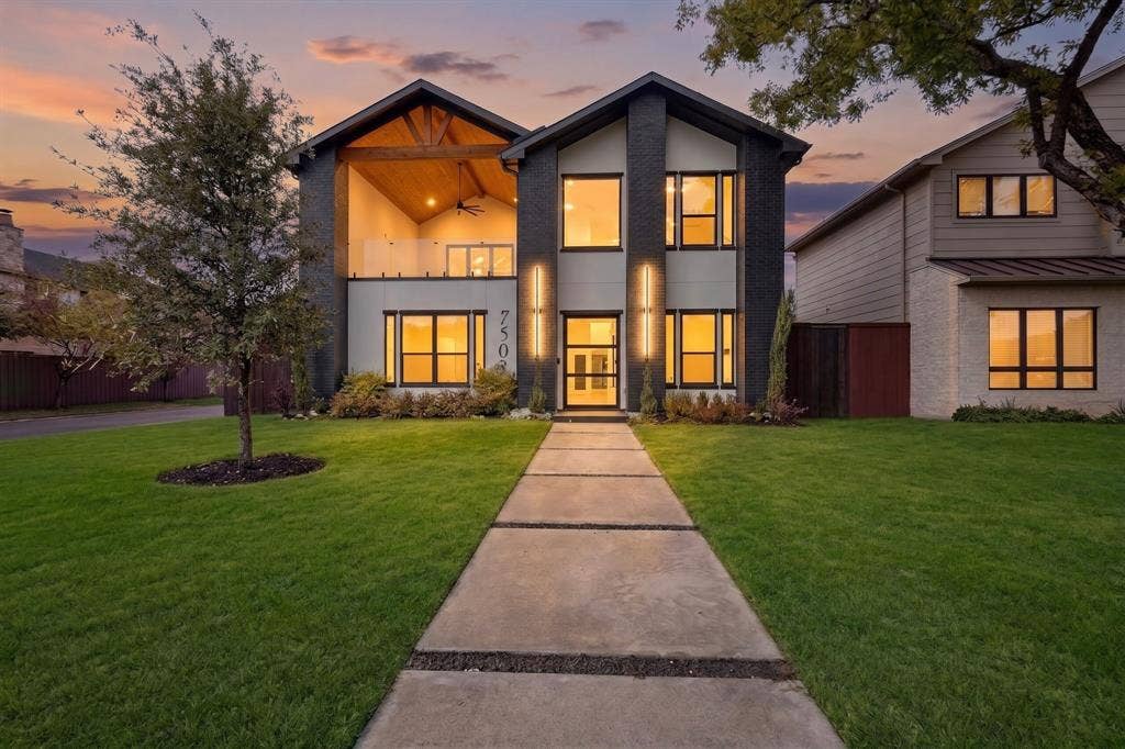 7503 Robin Road, Dallas, TX 75209 Modern exterior featuring dark masonry, a covered balcony with wood-paneled ceiling, integrated vertical lighting, and a paved walkway with stone aggregate detailing