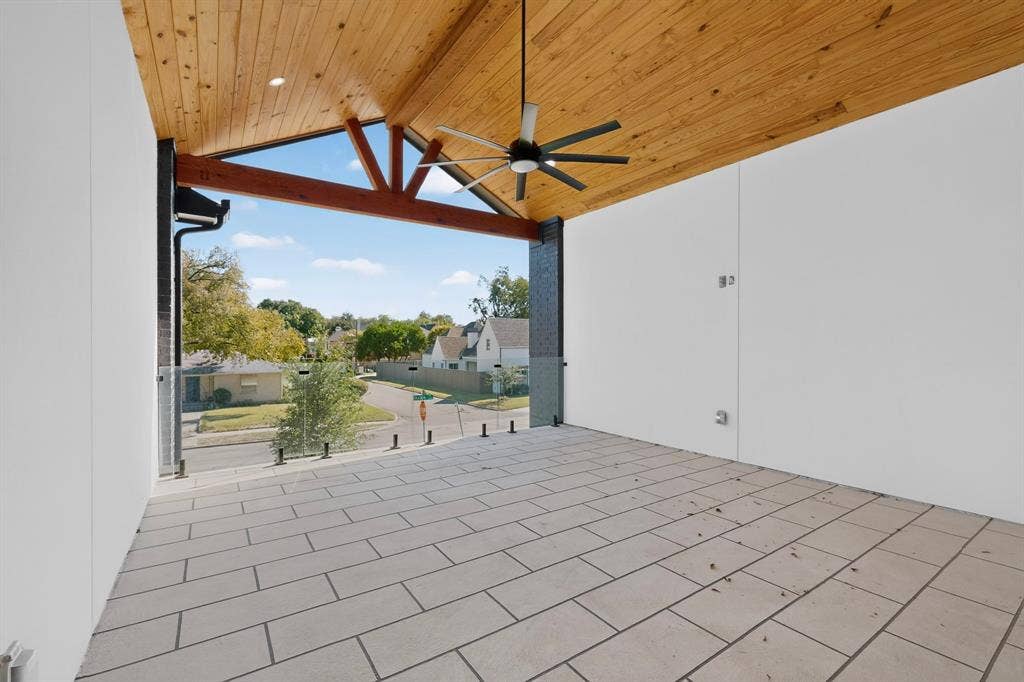 7503 Robin Road, Dallas, TX 75209 Covered balcony featuring a wood-plank vaulted ceiling, tiled flooring, exposed timber beam, and frameless glass railing with industrial-style standoffs
