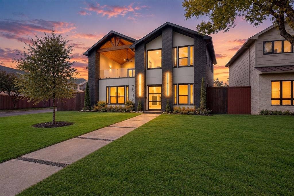 7503 Robin Road, Dallas, TX 75209 Modern two-story exterior featuring dark brick masonry, wood-accented vaulted balcony, glass railing, and linear wall-mounted exterior lighting