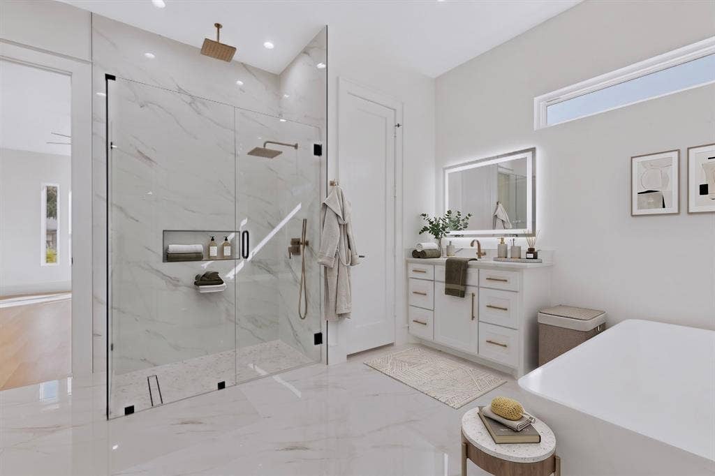 7503 Robin Road, Dallas, TX 75209 Walk-in glass-enclosed shower with a recessed niche and rain-style showerhead, vanity with dual-toned hardware and a back-lit mirror, and a soaking tub