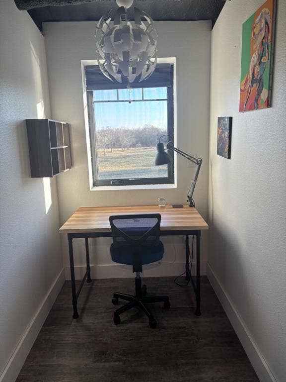 1794 County Road 4309 N, Greenville, TX 75401 Room featuring wood-finish flooring, a centrally positioned ceiling pendant light, a recessed wall-mounted shelving unit, and a window with exterior landscape exposure