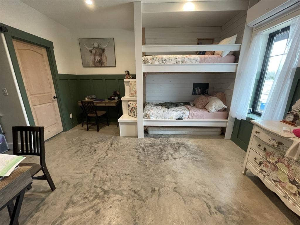1794 County Road 4309 N, Greenville, TX 75401 Built-in white bunk bed frame with integrated staircase, green wainscoting, smooth concrete flooring, multi-panel wood door, and recessed lighting