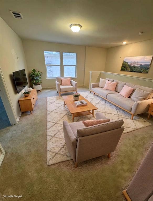 View of carpeted living area/den at top of stairs .