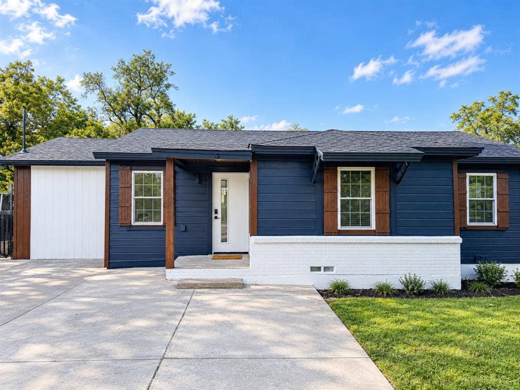 4522 Idaho Avenue, Dallas, TX 75216 Exterior featuring dark lap siding, white brick masonry, wood-finish shutters, and an integrated single-car garage
