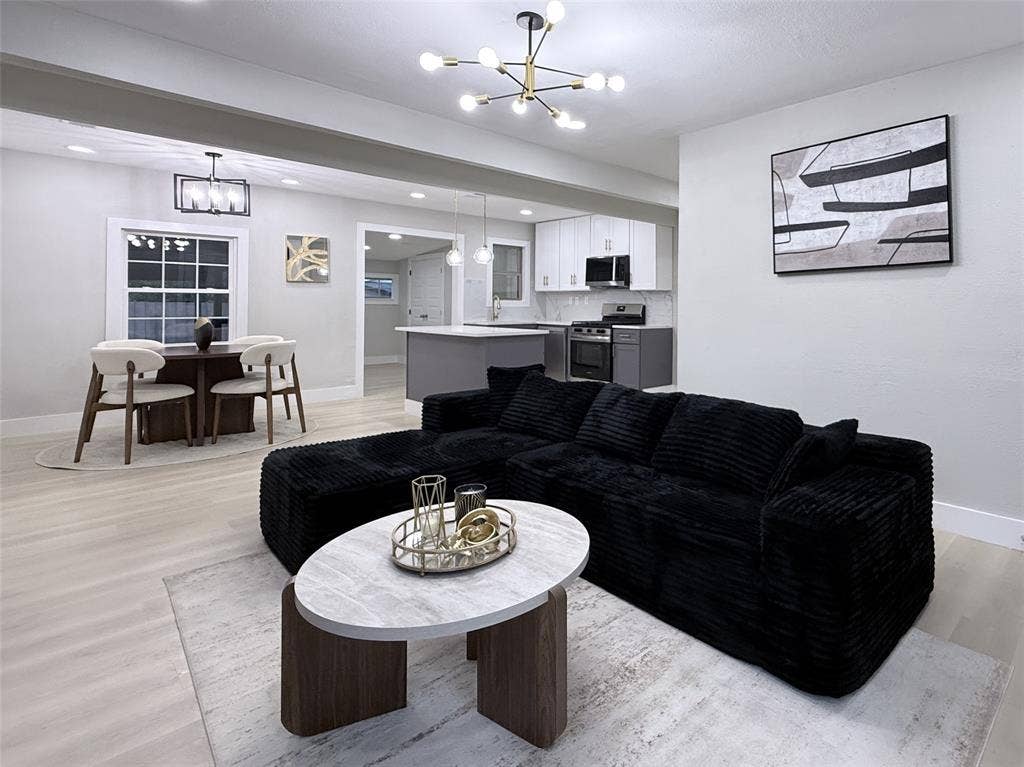 4522 Idaho Avenue, Dallas, TX 75216 Open concept interior featuring wood-finish flooring, recessed lighting, a modern multi-arm chandelier, and a kitchen with white upper cabinetry and a center island