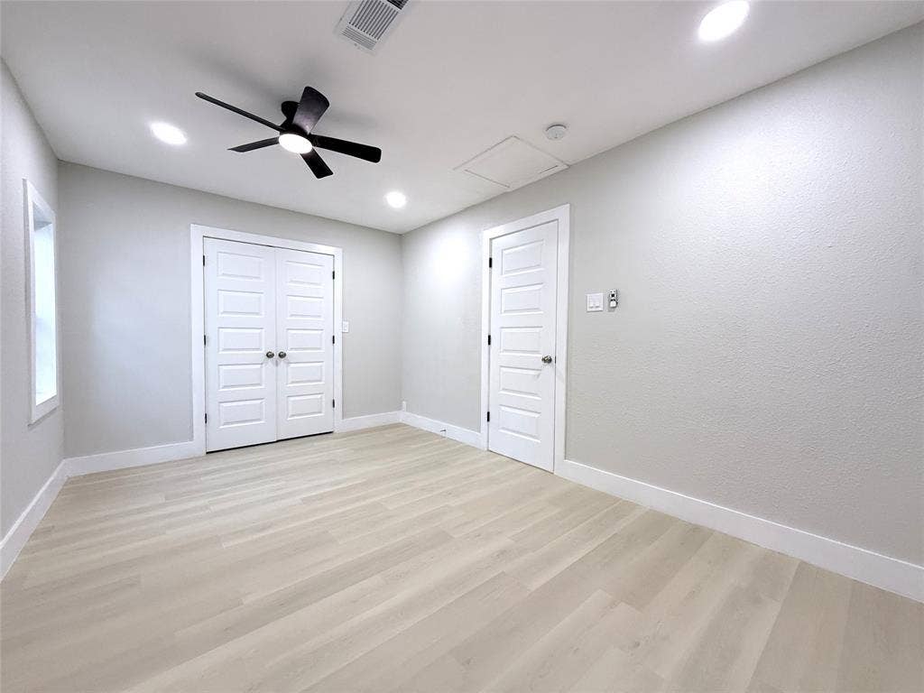 4522 Idaho Avenue, Dallas, TX 75216 Neutral-toned interior featuring wood-finish flooring, recessed lighting, matte black ceiling fan, and multi-panel doors