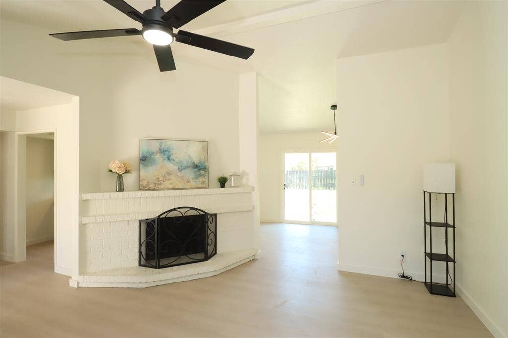1518 Burgundy Street, Garland, TX 75040 Corner fireplace featuring painted brick masonry, brand new sliding glass patio doors