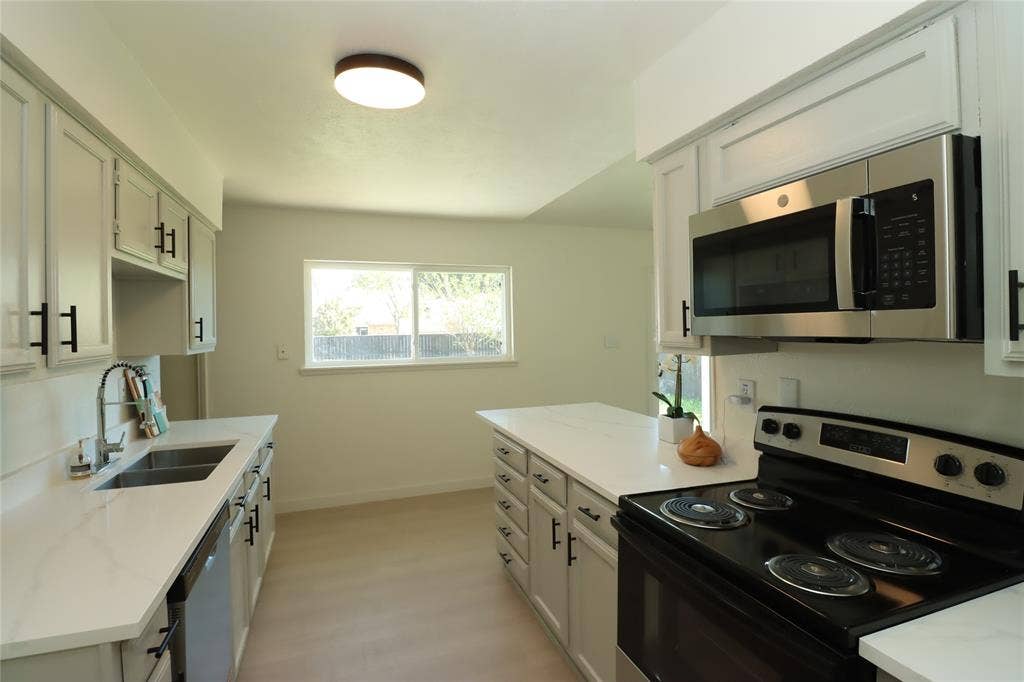 1518 Burgundy Street, Garland, TX 75040 New stainless steel microwave, black electric range, and double-basin stainless steel sink with a high-arch pull-down faucet!
