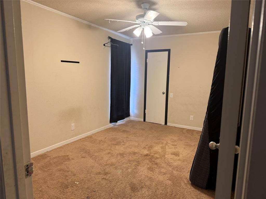 3825 Eugene Court N, Irving, TX 75062 Room featuring neutral-toned carpeting, a ceiling-mounted light fixture with a central fan, and a single-panel interior door