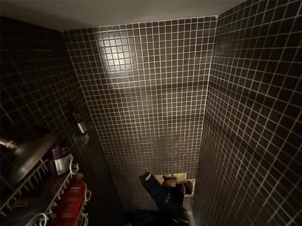3825 Eugene Court N, Irving, TX 75062 Shower surround featuring dark, square-grid mosaic wall tile and a fixed showerhead